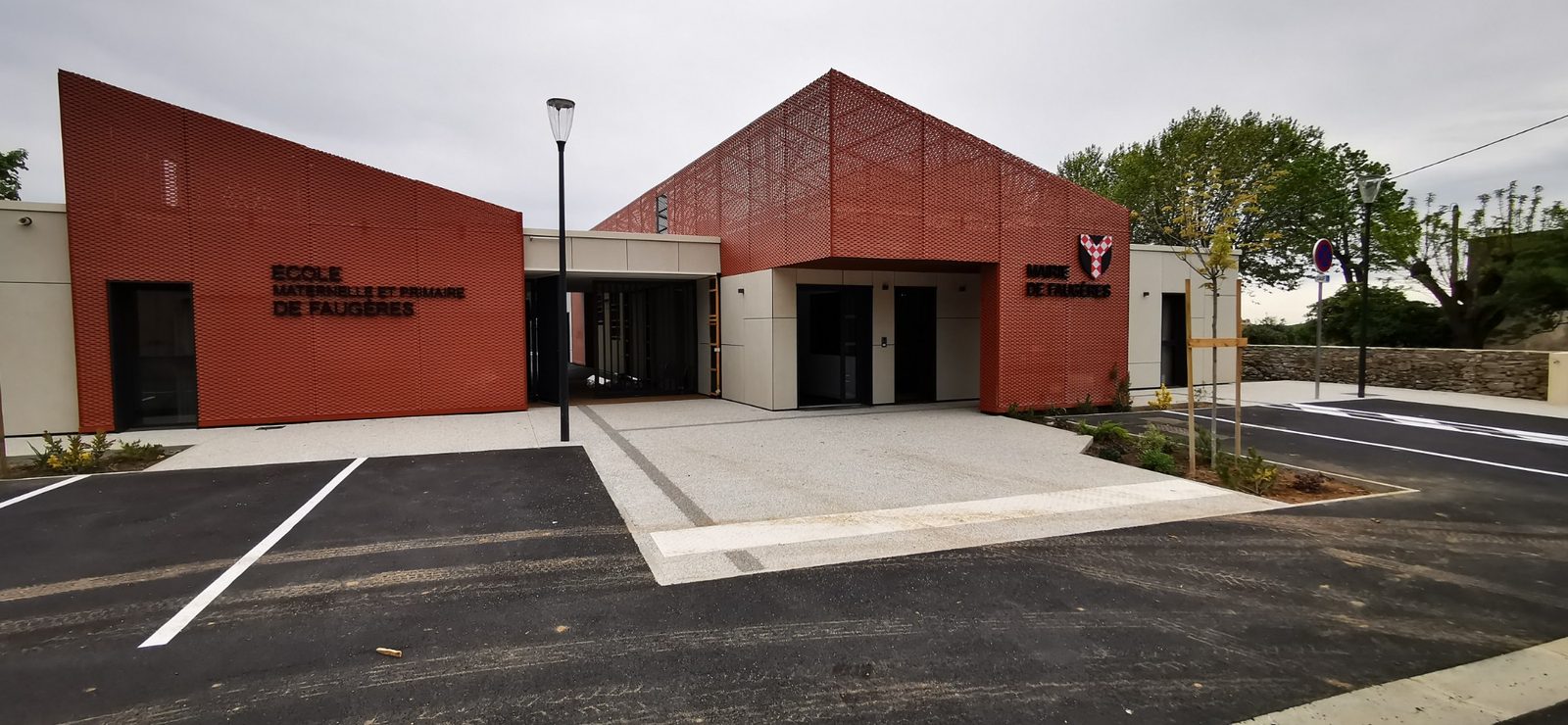 École et mairie de Faugères, façades en containers habillées de métal déployé rouge