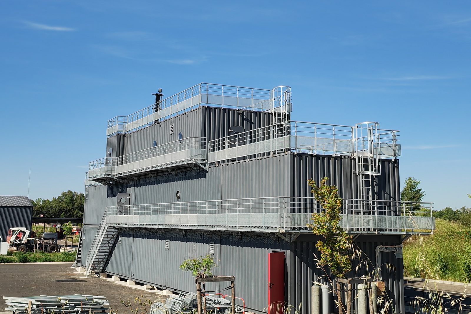 Ouvrage de containers empilés sur deux niveaux avec coursives et escaliers