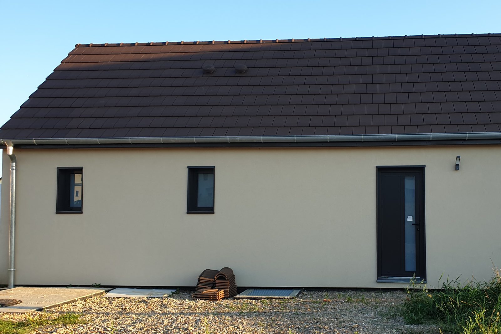 Maison en containers avec toit à deux pans en tuiles et façades enduites, en Alsace