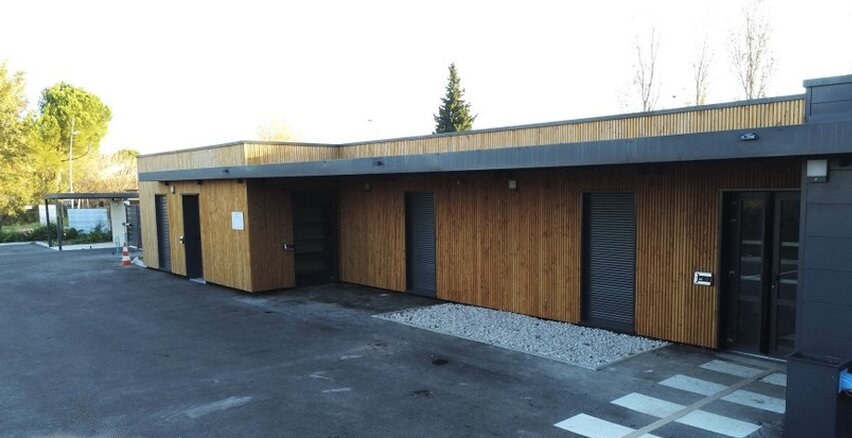 Centre de supervision urbaine en containers habillés de bardage bois, avec son parvis